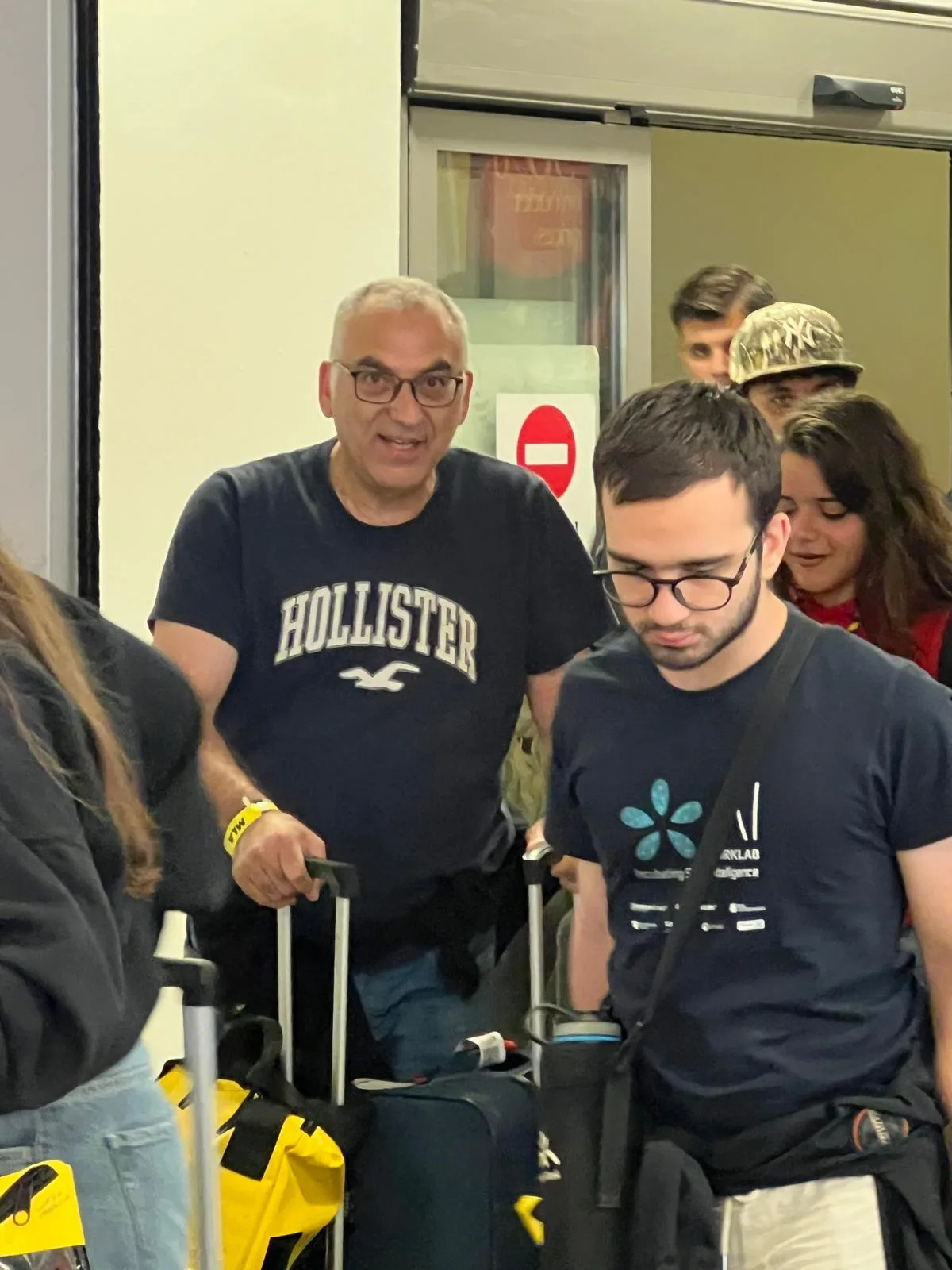Un papà accoglie il figlio all’arrivo, tra le valigie, nel corridoio arrivi dell’aeroporto di Napoli Capodichino