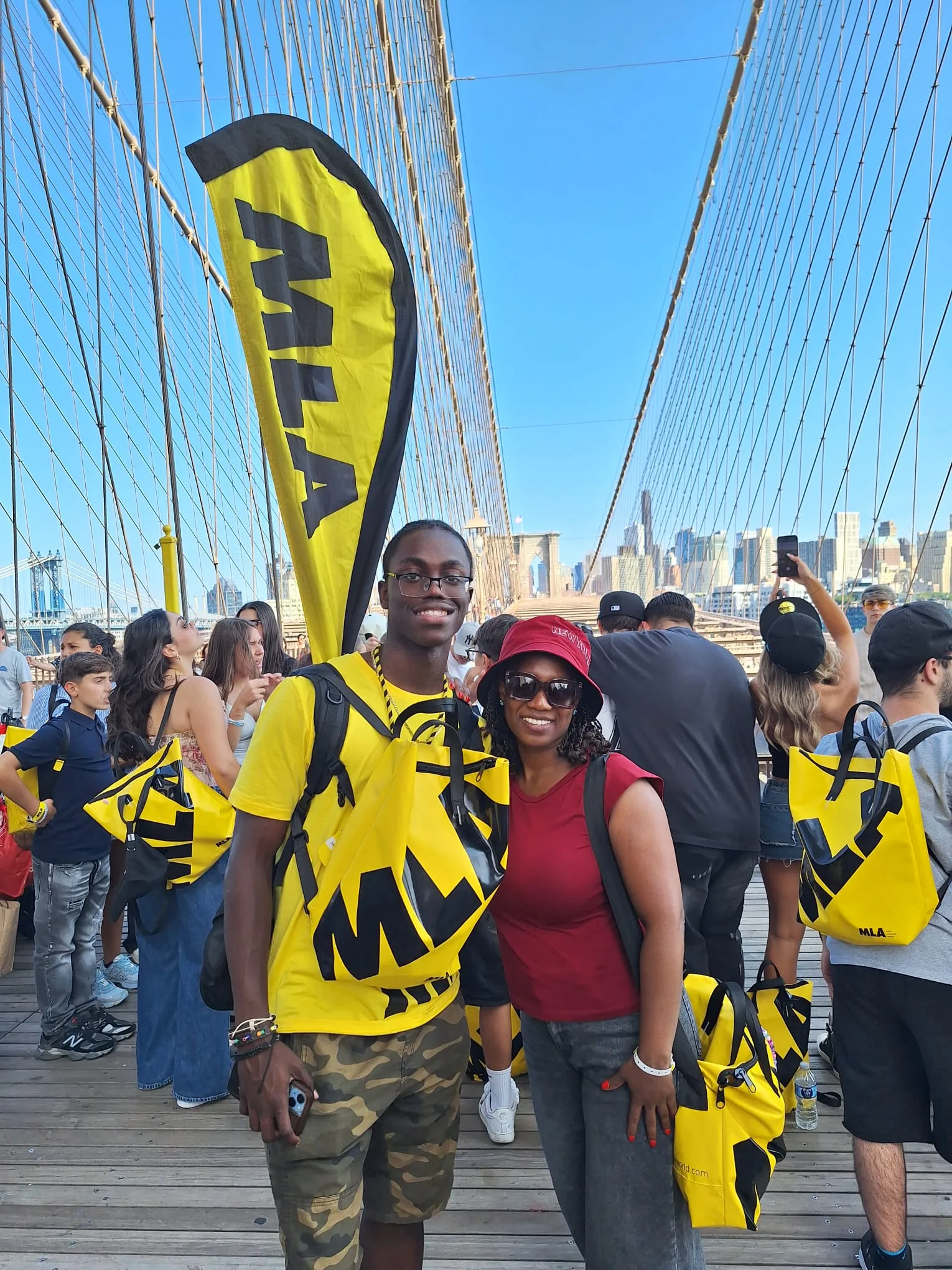 Foto con la bandiera MLA sul ponte di Brooklyn, skyline di Manhattan sullo sfondo