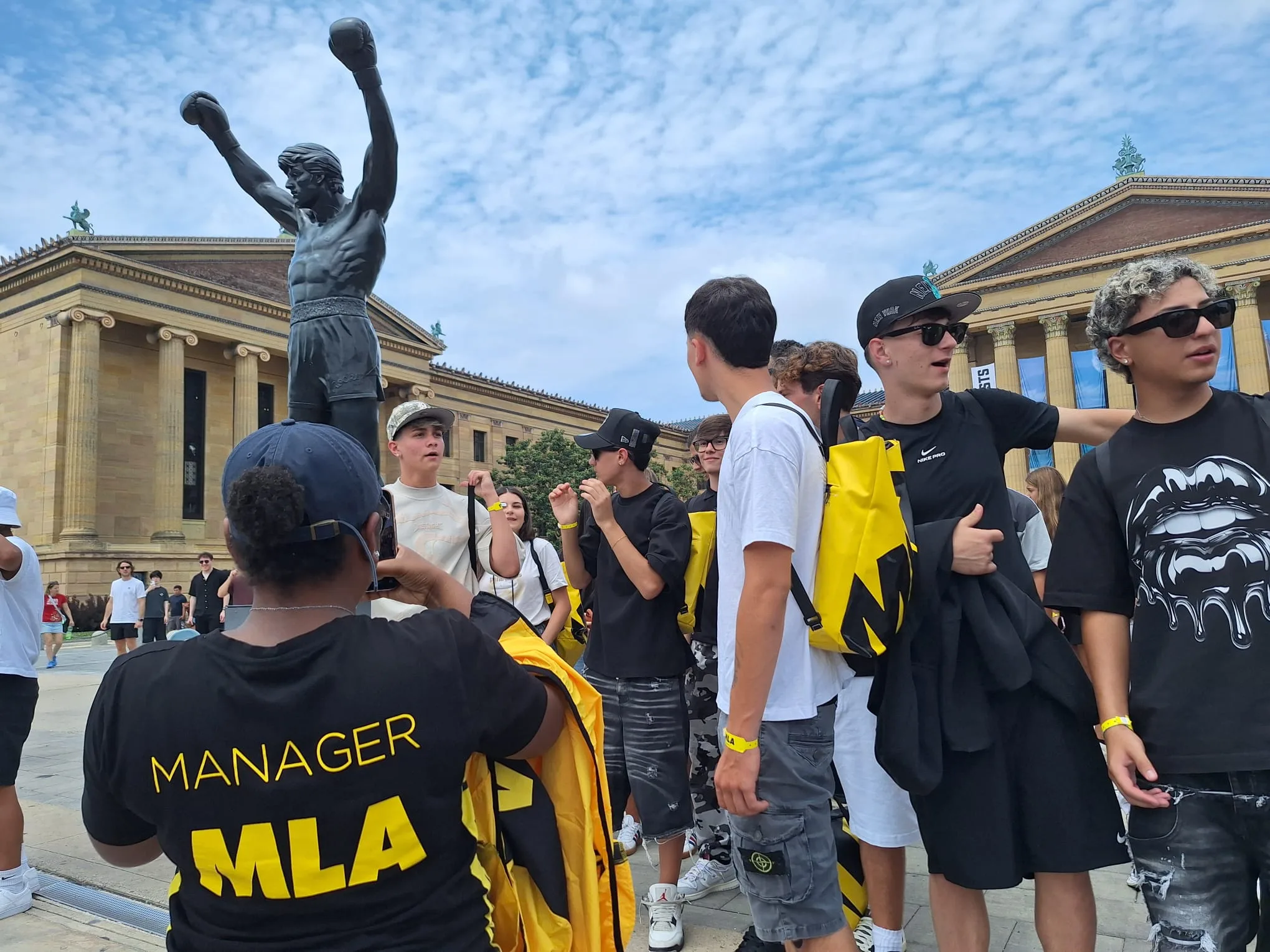 Il gruppo con la maglietta Manager MLA e gli zaini gialli davanti al museo