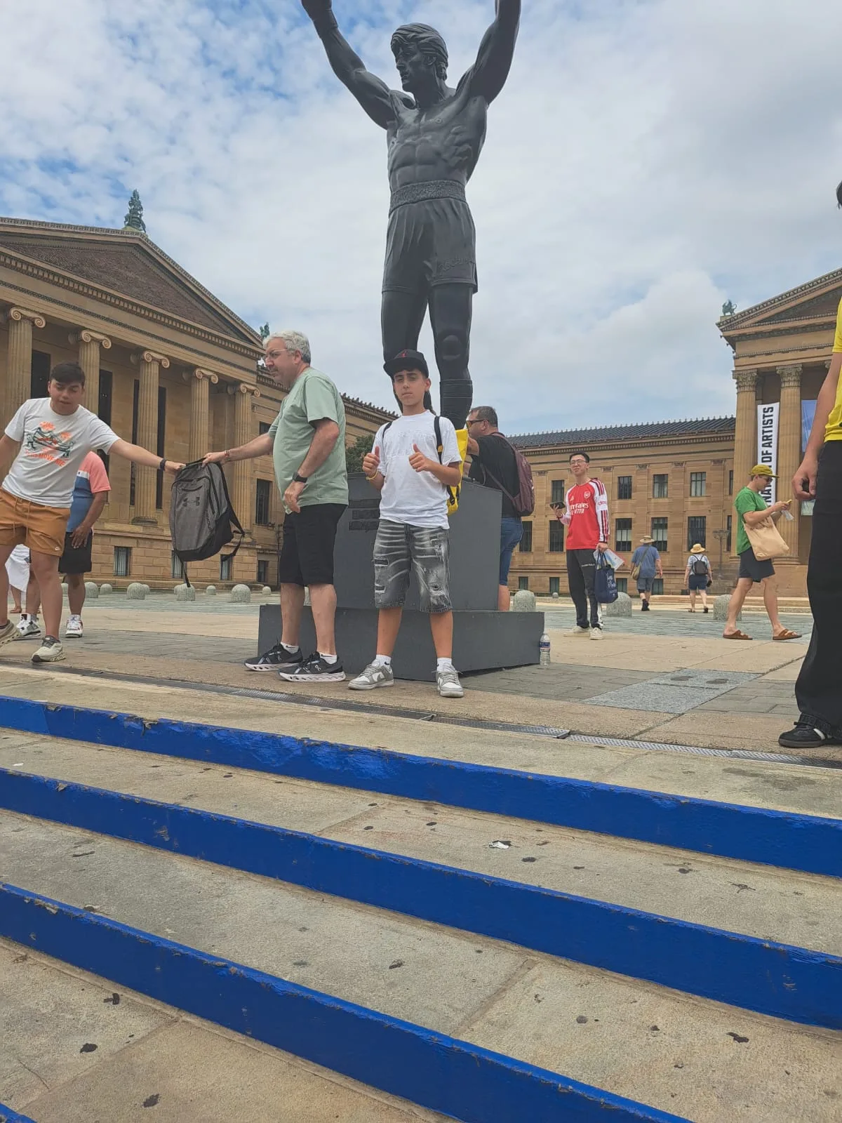 Uno studente in posa sui gradini iconici ai piedi della statua di Rocky Balboa