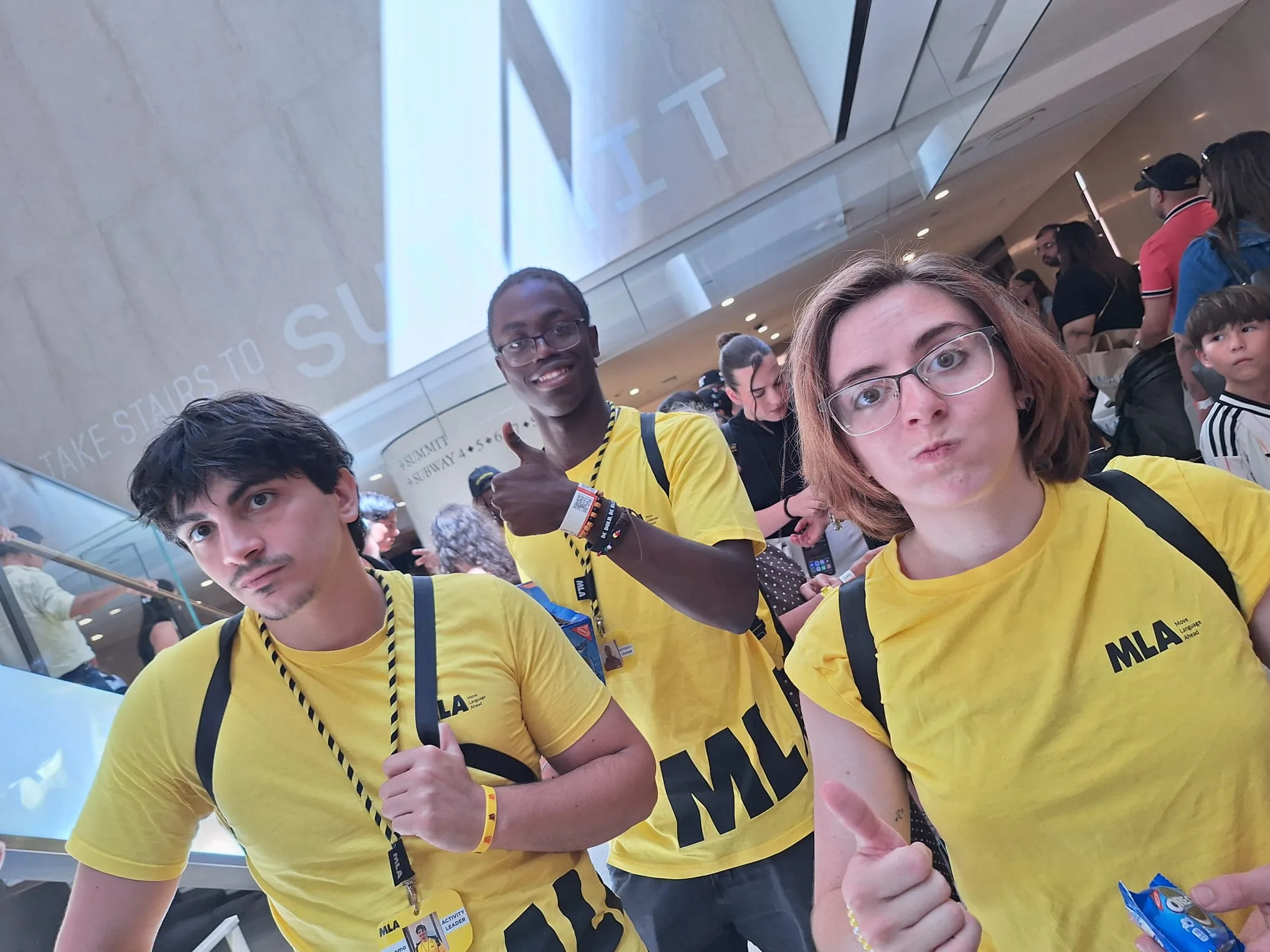 Tre ragazzi con la maglietta gialla MLA all’ingresso di SUMMIT One Vanderbilt